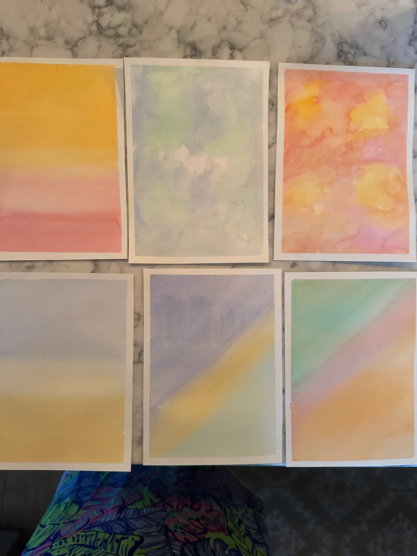 Six student watercolour graded wash studies in sunset, green and lilac tones